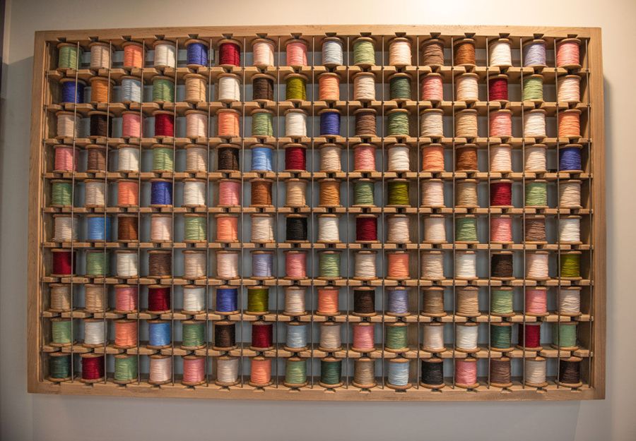 A wall display of hundreds of colorful thread spools, a nod to Danville’s textile mill history