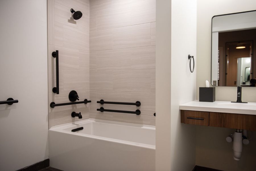 ADA accessible bathroom with grab bars and tub shower