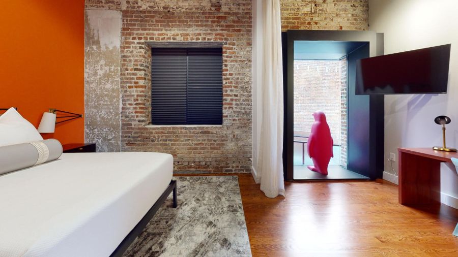 Bedroom looking toward a window alcove with a red penguin sculpture