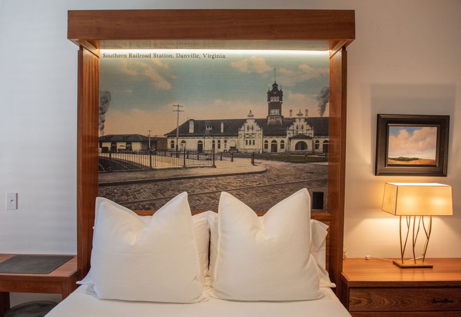 Backlit sapele headboard framing a vintage postcard of the Southern Railroad Station in Danville