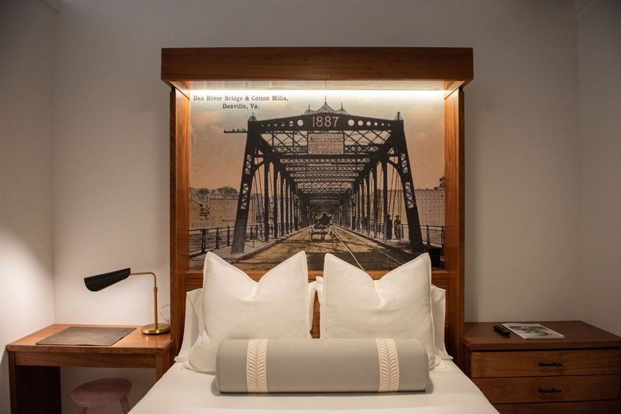 Close view of the backlit headboard postcard of the Dan River Bridge and Cotton Mills, Danville, Va., with a writing desk and nightstand