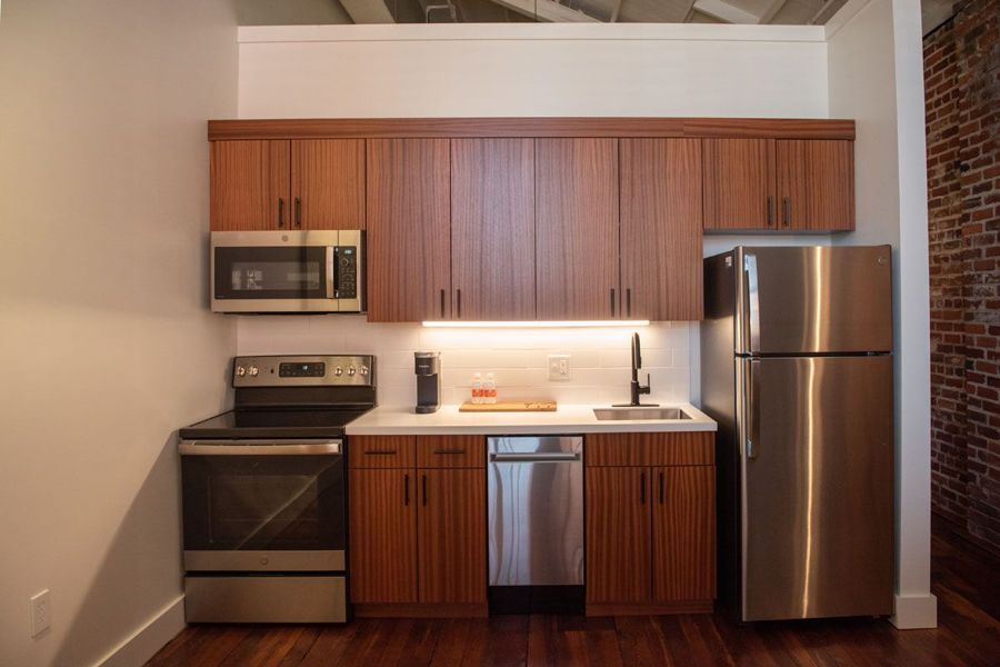 Kitchen with sapele wood cabinetry, under-cabinet lighting and stainless steel appliances